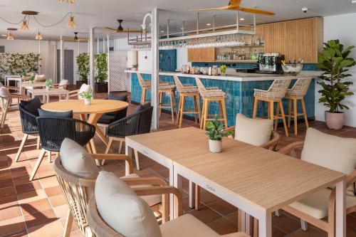 a restaurant with tables and chairs and a bar at Meliá Madrid Barajas in Madrid