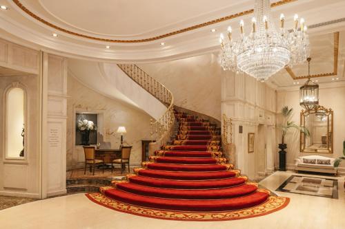 a red carpet staircase in a building with a chandelier at Hotel Fénix, a Gran Meliá Hotel - The Leading Hotels of the World in Madrid