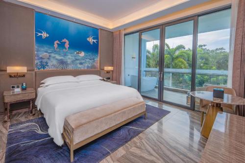 a bedroom with a large bed and a large window at Vaperse Hainan Clear Water Bay in Lingshui