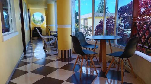 a balcony with a table and chairs and windows at Hostal Mariscal Sucre in Tababela