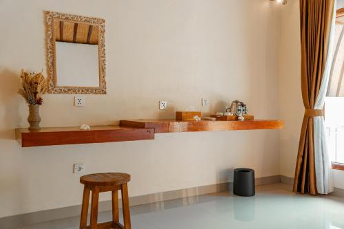 a bathroom with a sink and a mirror and a stool at The Kaci Penida By Bali Cabin in Nusa Penida