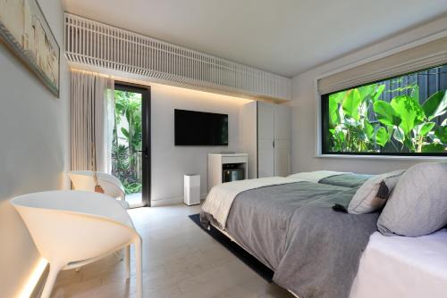 a bedroom with a bed and a large window at Tree Villa Bangkok in Bangkok
