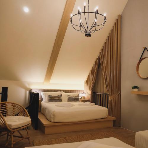 a bedroom with a bed and a chandelier at Oxygen Cloud Khaoyai Managed by OHS in Ban Bung Toei