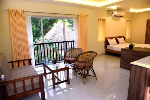 a living room with a bed and a table and chairs at Villa Varkala in Varkala