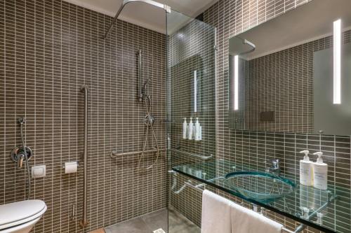 a bathroom with a glass shower and a toilet at AC Hotel Bologna by Marriott in Bologna