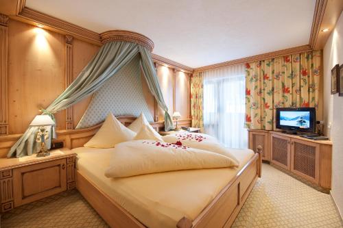 pokój hotelowy z łóżkiem i telewizorem w obiekcie Hotel Jagdhof Bed & Breakfast w mieście Obergurgl