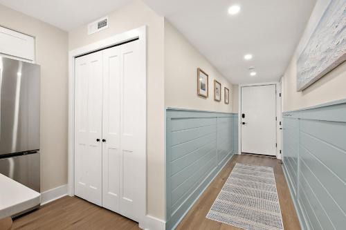 a walk in closet with white cabinets and a blue door at Ocean Side Beach Condo in Ocean City