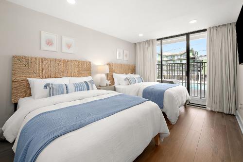 two beds in a hotel room with a window at Ocean Side Beach Condo in Ocean City