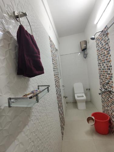 a bathroom with a toilet and a shower curtain at NHM Stays in Garui