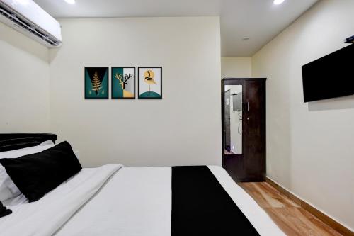 a bedroom with a black and white bed and a tv at Hotel O Satyam Junction Seethammadhara in Visakhapatnam