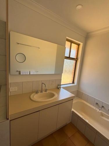 a bathroom with a sink and a bath tub at Sittella's Vineyard Residence in Herne Hill
