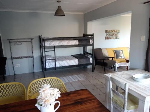 a living room with bunk beds and a table at Perdekuil in Stilbaai-Wes