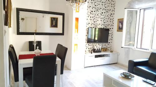 a living room with a dining table and a television at Apartment Kiki in Kotor