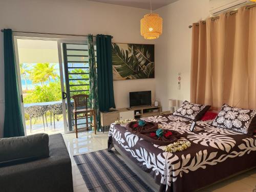 a living room with a bed and a couch at Vaihi's Garden climatisé, vue sur mer - Huahine in HUH