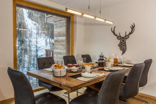 a dining room with a wooden table and chairs at Chalet Les Rahâs by Mrs Miggins in Grimentz