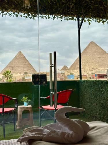 a room with chairs and a table with pyramids in the background at Master kings of the pyramids and Sphinx in Cairo