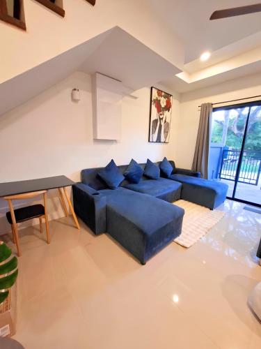 a living room with blue couches and a table at Sunday House - Fisherman Village Samui in Bophut