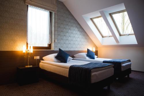 En eller flere senge i et værelse på Hotel Cztery Pory Roku