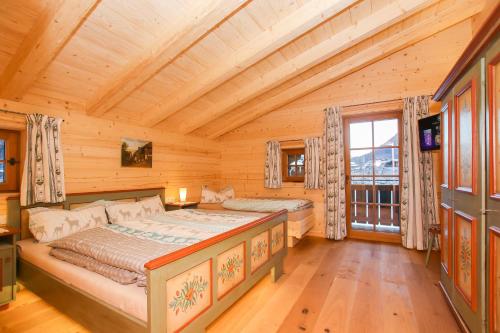 um quarto com 2 camas num chalé de madeira em Chalet am Müllergut em Sankt Martin bei Lofer