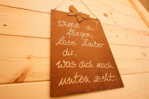a sign hanging on a wall with writing on it at Chalet am Müllergut in Sankt Martin bei Lofer