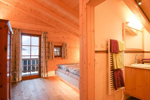 a log cabin bedroom with a sink and a window at Chalet am Müllergut in Sankt Martin bei Lofer