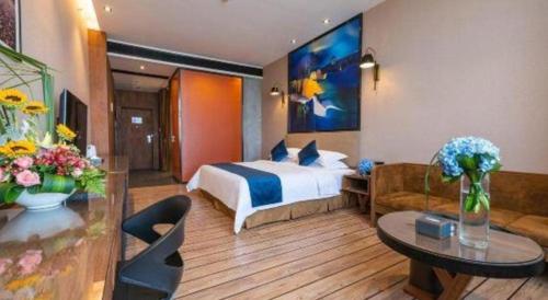 a hotel room with a bed and a couch at MAIHAOHOTELS in Huangdong