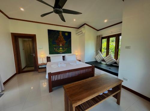 a bedroom with a large bed with a ceiling fan at keio place in Thong Nai Pan Yai