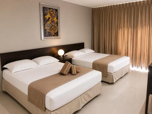 a hotel room with two beds in a room at Hotel de Cuautla in Cuautla Morelos