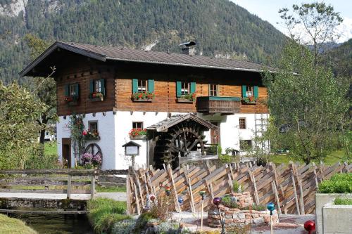 a building with a wooden fence in front of it at Frühstückspension Müllergut in Sankt Martin bei Lofer