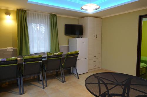 um quarto com uma mesa e cadeiras e uma televisão em Mesteri Apartman 1A-B em Mesteri
