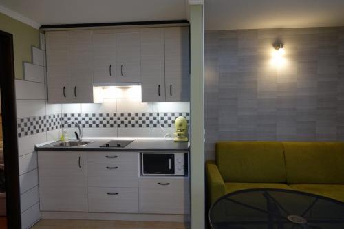 a kitchen with a sink and a couch in a room at Mesteri Apartman 1A-B in Mesteri