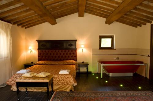a bedroom with a bed and a tub and a table at Agriturismo Ca' Montioni in Mercatello sul Metauro