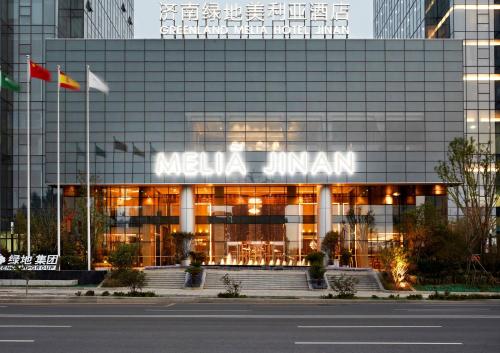 a large glass building with a sign on it at Meliá Jinan in Jinan