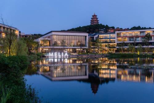 a building with its reflection in the water at night at Meliá Chongqing in Chongqing