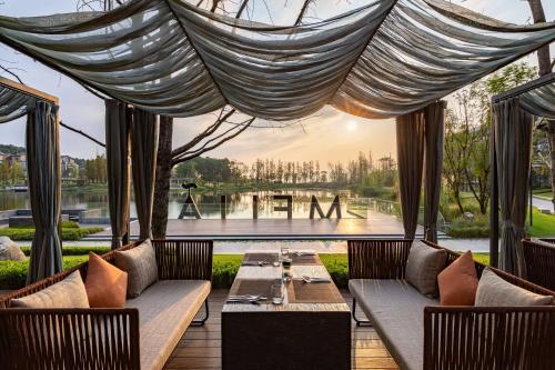 a patio with a table and chairs and a view of a lake at Meliá Chongqing in Chongqing