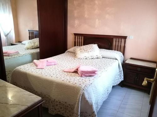 セビリアにあるSleepIn Trianaのベッドルーム1室(ピンクのタオル2枚付)