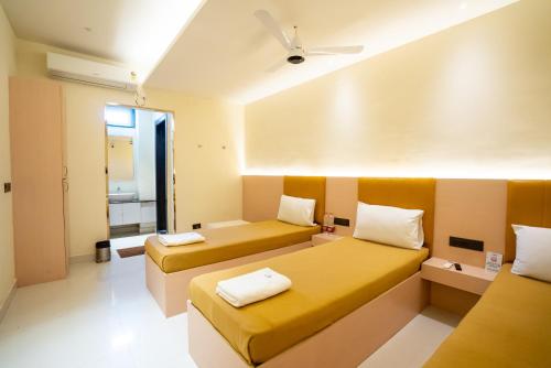 a hotel room with two beds and a window at Freshup Hotel in Tirupati