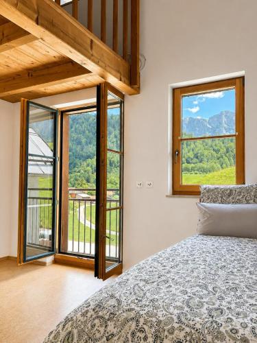 a bedroom with a bed and a large window at NaturZeit Melleck in Schneizlreuth