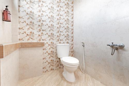 a bathroom with a white toilet in a room at Urbanview Syariah Hotel Kanigara Batu in Batu