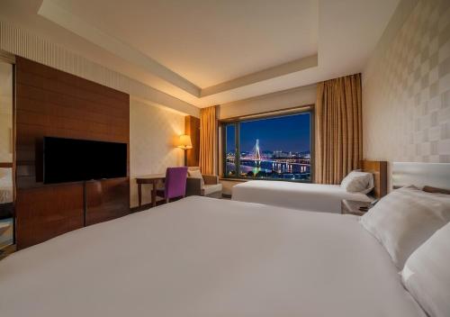 a hotel room with a large bed and a large window at Niagara Hotel in Seoul