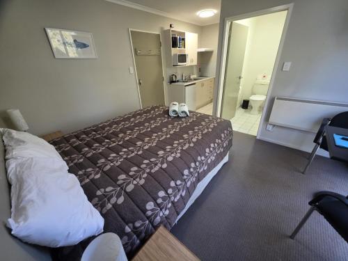 a hotel room with a bed with two stuffed animals on it at Opuke Studio Methven in Methven