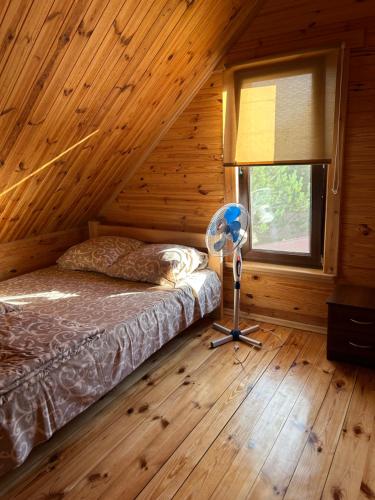 a bedroom with a bed in a log cabin at Cottages on Polyova in Zgorany
