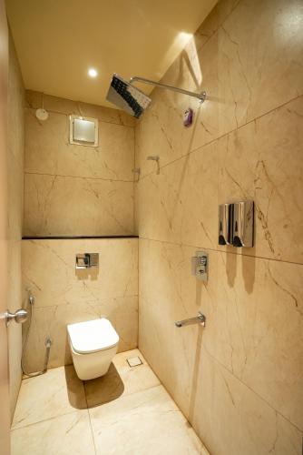 a bathroom with a toilet and a shower at Freshup Hotel in Tirupati