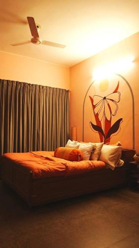 a bedroom with a bed with a flower on the wall at The Saanj Villa in Sānand