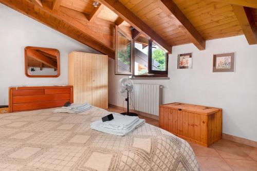 a bedroom with a bed and a fan in it at Maison Adriano Lago Maggiore in Sangiano