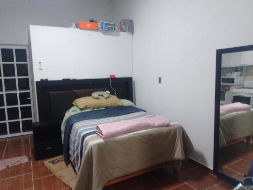 a bedroom with a bed and a mirror in it at Oscar in Poza Rica de Hidalgo