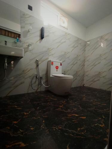 a bathroom with a toilet and a sink at Dambulla Tiger Rock Hotel with Mountain Viewpoint in Dambulla