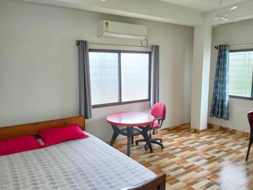 a bedroom with a bed and a table and chairs at Yangzom Homez in Siliguri