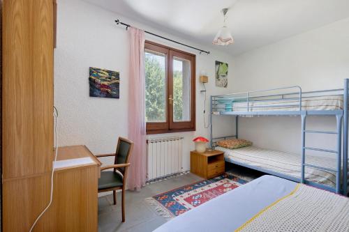 a bedroom with a bunk bed and a desk and a desk at La Pennica bnb in Pontremoli