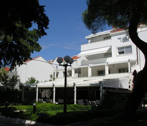a white building with a street light in front of it at Apartments Villa Alba in Dubrovnik